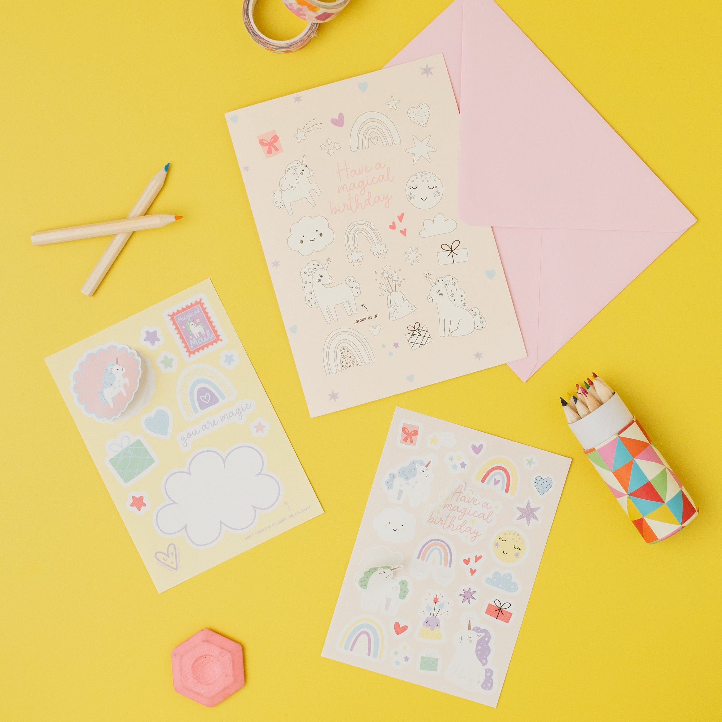 Colorful stationery items including stickers, paper, and markers on a yellow background