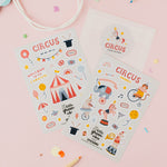Circus-themed sticker sheets on a pink background with colourful confetti and pencils.