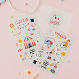 Circus-themed sticker sheets on a pink background with colourful confetti and pencils.
