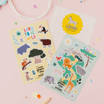 Set of safari animal-themed stickers on a pink background with pencils and a bag.